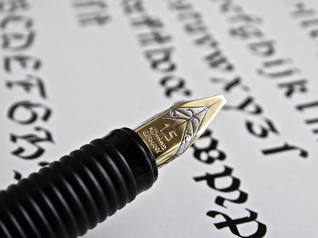 Fountain pen with Italic nib over a paper filled with black italic text