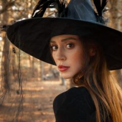 Woman dressed as a witch looks over her shoulder towards the camera