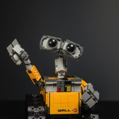 Robot with large eyes, yellow body and friendly wave