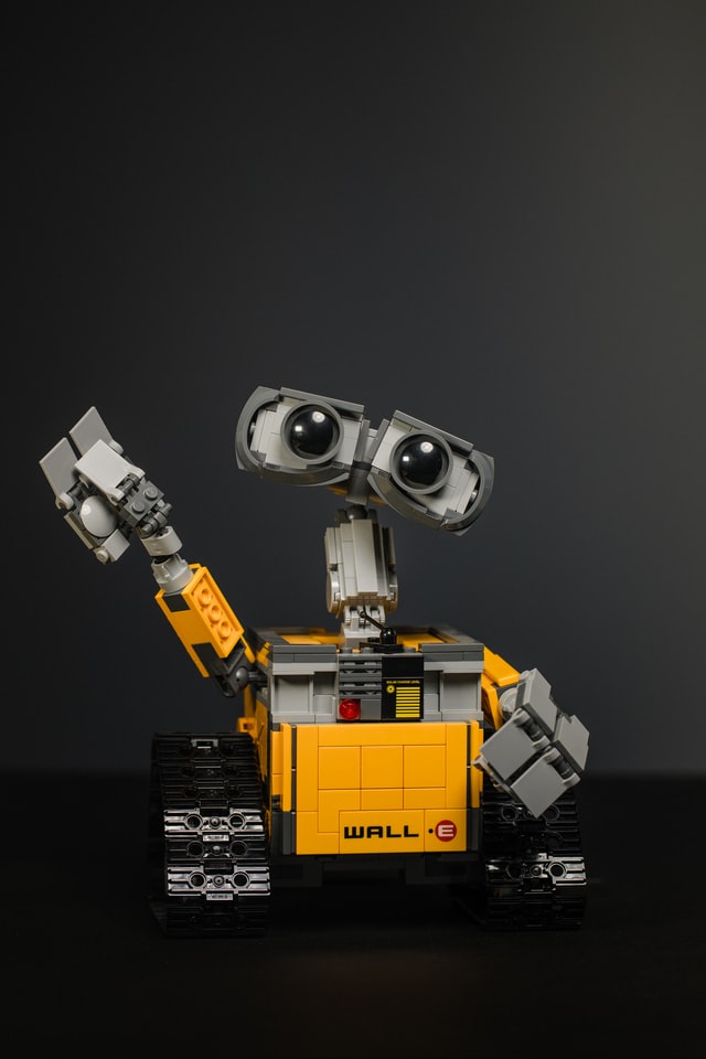 Robot with large eyes, yellow body and friendly wave