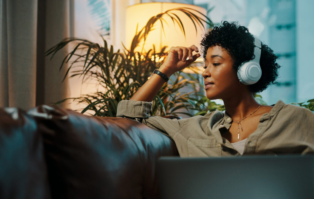 African American woman sits in tranquil environment listening to audio set