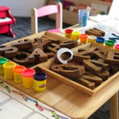Nursey School Table with paint jars and wooden alphabet letters